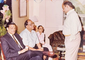 Ajay Rungta (Dadu) seated with glasses, flanked by a brother and Buaji, with another brother standing, in a casual family gathering.