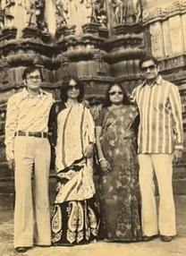 Sepia photo: Ajay Rungta and three friends (a man and two women in sarees and sunglasses) standing before a detailed temple carving.