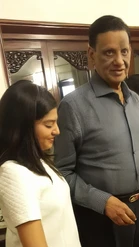 Ajay 'Dadu' Rungta next to granddaughter Aaina. Dadu in grey shirt looks at camera; Aaina in white top smiles, looking down.