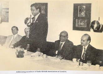 Sepia photograph: Ajay Rungta (Dadu) stands addressing seated members at an Indo-British Association meeting in London.