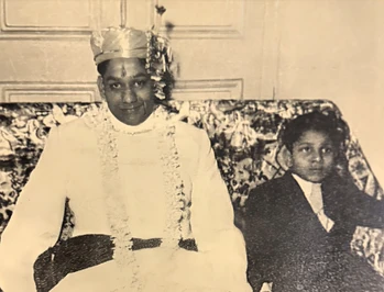Vintage sepia photo of Ajay Rungta in wedding turban and attire, seated with his bride on a patterned sofa. From his wedding day.