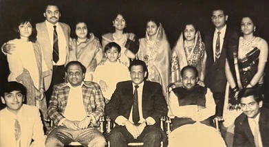 Sepia group portrait: Rungta brothers Ajay, Kamal, and Ashok seated, surrounded by children and younger family members.
