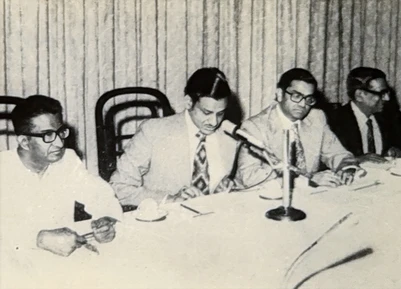 Ajay Rungta (Dadu, second from left) and three colleagues at a formal meeting. Black and white photo of men at a table.
