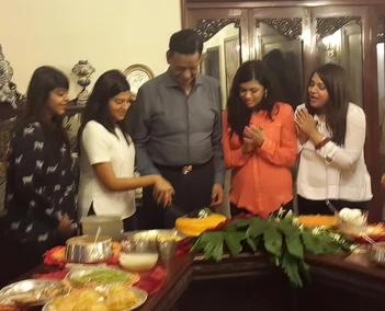 Ajay Rungta (Dadu) with granddaughters at his birthday. One cuts the cake at Poddar House, others watch happily.