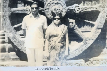 Dadu (Ajay Rungta) and companion in sunglasses at Konark Temple, by a carved stone wheel. Vintage B&W photo.